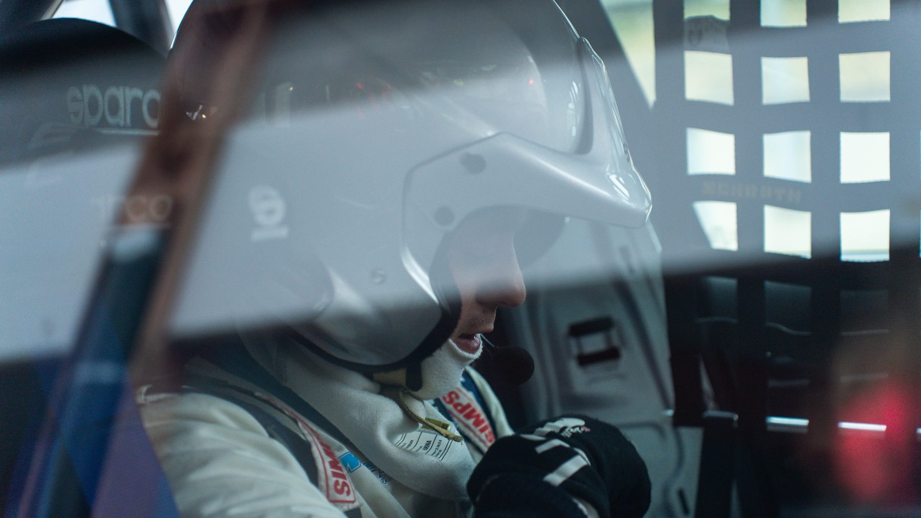 Coureur met helm in cockpit Audi RS3 TCR close-up door venster