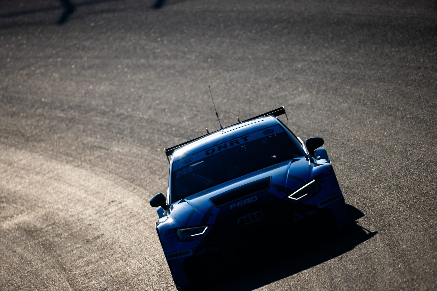 Audi RS3 TCR #246 in avondlicht op het circuit, koplampen aan